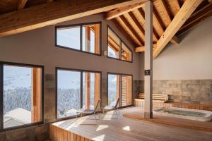 フレーヌにあるDormio Resort Les Portes du Grand Massifのホットタブと窓が備わる客室です。