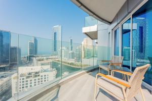 a balcony with two chairs and a view of the city at Stayis - 1 BR Marina suite in Dubai