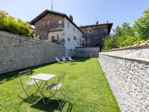 une table et des chaises dans une cour à côté d'un mur en pierre dans l'établissement Apartment Il Giardino Segreto-7 by Interhome, à Cividale del Friuli