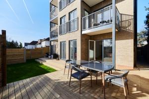 a patio with a table and chairs in front of a building at The Wembley Park Secret - Spacious 3BDR Flat with Terrace in London