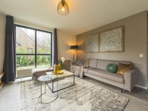 uma sala de estar com um sofá e uma mesa em Holiday Home VIP Wellness Ewijk by Interhome em Ewijk