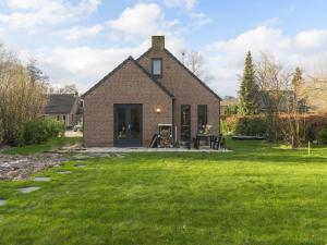 uma casa de tijolos com um relvado em frente em Holiday Home VIP Wellness Ewijk by Interhome em Ewijk