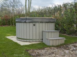 uma casa de banho na relva num quintal em Holiday Home VIP Wellness Ewijk by Interhome em Ewijk