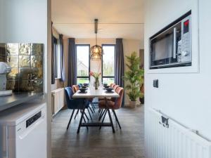 uma cozinha e sala de jantar com mesa e cadeiras em Holiday Home VIP Wellness Ewijk by Interhome em Ewijk