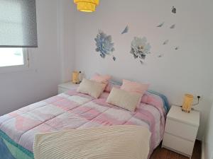 Un dormitorio con una cama con sábanas rosas y moradas. en Ático Bella Vista, en Cómpeta