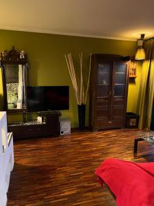 uma sala de estar com paredes verdes e piso em madeira em Apartament Brzozowa em Chorzów