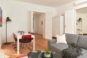 ein Wohnzimmer mit einem Sofa und einem Tisch in der Unterkunft Elegant Premium Apartment in Central Vienna (Naschmarkt) in Wien