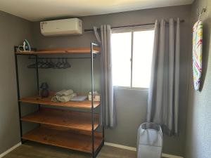 une chambre avec une étagère et une fenêtre dans l'établissement Confortável Kitinete Duplex, à Fortaleza