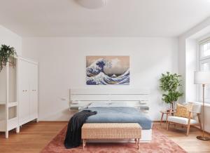 ein Schlafzimmer mit einem Bett und einem Gemälde einer Welle in der Unterkunft Elegant Premium Apartment in Central Vienna (Naschmarkt) in Wien