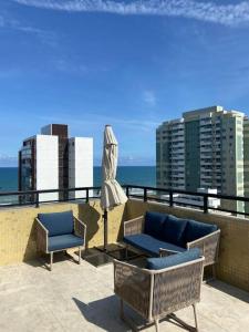 a patio with two chairs and a couch and an umbrella at Palazzo di Milano in Ilhéus +16 photos