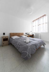 - une chambre avec un grand lit et une couette grise dans l'établissement Le Bardin - Grand appartement design, parking gratuit, à Vichy