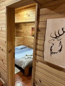 um pequeno quarto com uma cama num chalé de madeira em Mountain Lodge T3 Duplex Abrigo do Lobo na Covilhã