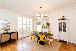 comedor con mesa y sillas amarillas en Spacious luxury apartment near Monmartre en París