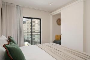 a bedroom with a bed and a large window at Santa Luzia III by An Island Apart in Funchal +7 photos
