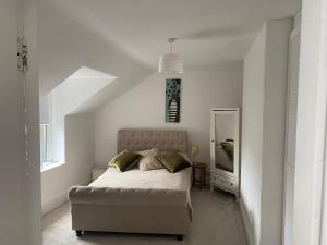 biała sypialnia z łóżkiem i lustrem w obiekcie Lovely 2 Bedroom Loft Apartment in Buxton w mieście Buxton