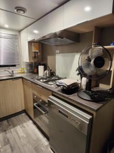 a kitchen with a fan on top of a counter at Mobile-home Bonne -Anse Plage in Les Mathes