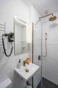 a white bathroom with a sink and a shower at City Lodge in the Heart of Sofia in Sofia