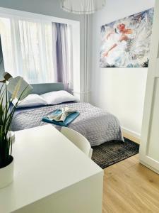 1 dormitorio con 1 cama y una pintura en la pared en Apartament pod Zamkiem, en Szczecin