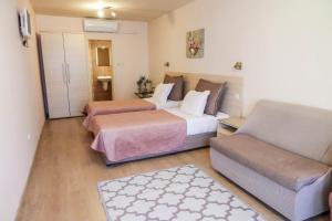a hotel room with two beds and a couch at Hotel Acropolis in Varna City