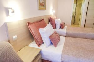 Habitación de hotel con 2 camas y almohadas en Hotel Acropolis, en Varna