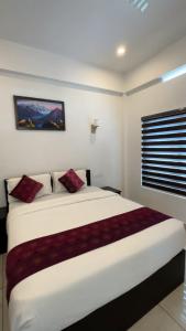 a bedroom with a large white bed with red pillows at Himasailam Resort in Vagamon
