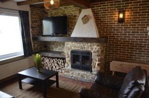 a living room with a brick fireplace with a tv at Le Refuge du Grand Mitan in IsiÃ¨res