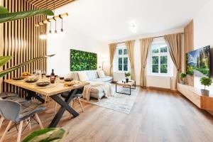 ein Wohnzimmer mit Tisch und Couch in der Unterkunft The Forest Apartment - Sauna, Center & Wood in Karlsbad