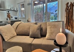 ein Wohnzimmer mit einer Couch mit einer Kerze auf dem Tisch in der Unterkunft Snow Home by So'SerenityHome-Jardin-Parking-Calme in Marignier