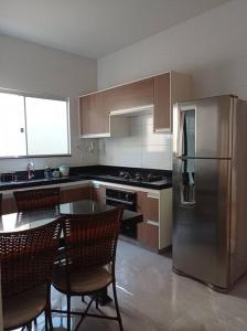 a kitchen with a stainless steel refrigerator and chairs at Casa completa em Ituiutaba Ar condicionado in Ituiutaba +41 photos