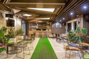ein Zimmer mit Tischen und Stühlen und grünem Boden in der Unterkunft Cat Ba Paradise Hotel- Pool & Sky Bar in Cát Bà