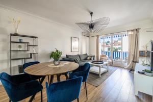 勒卡內的住宿－Grand 2 Pièces avec une belle terrasse *Le Cannet，客厅配有桌子和蓝色椅子