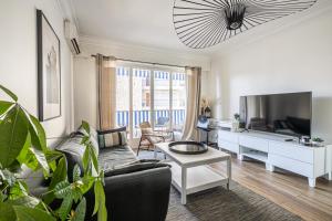 a living room with a couch and a tv at Grand 2 Pièces avec une belle terrasse *Le Cannet in Le Cannet