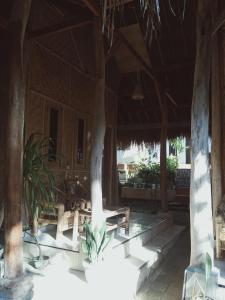 a patio with tables and chairs in a building at Azka Homestay in Kuta Lombok