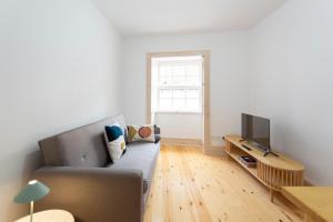 a living room with a couch and a television at Vinum Apartament 1890 in Coimbra