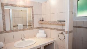 bagno bianco con lavandino e specchio di Résidence U Pirellu a Porto Vecchio