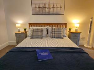 a bedroom with a bed with a book on it at Beachcomber B&B in Tenby