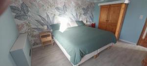 a bedroom with a green bed with a wall at Le Refuge du Grand Mitan in IsiÃ¨res