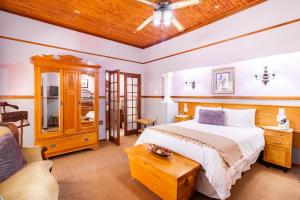a bedroom with a large bed and a couch at Kleine Eden Guesthouse in Bloemfontein