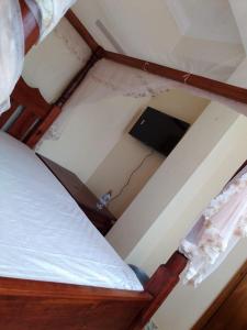 Cette chambre mansardée comprend un lit avec un mur cassé. dans l'établissement Dreams lodge, à Busia