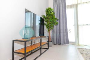 einen Schminktisch mit Spiegel und Topfpflanze in der Unterkunft Modern 1 Bedroom In Reflections in Abu Dhabi