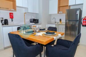 a kitchen with a wooden table and blue chairs at Modern 1 Bedroom In Reflections in Abu Dhabi