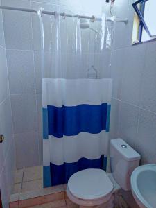 e bagno con servizi igienici e tenda doccia blu e bianca. di Espaço da Cris a Saquarema