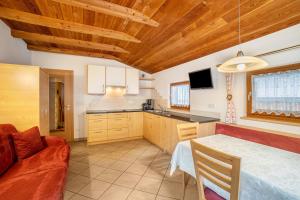 a kitchen with a table and a couch in a room at Speckign Apartment 3 in Cadipietra +10 photos