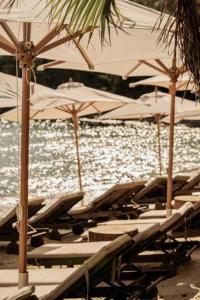 a group of lounge chairs and umbrellas on a beach at Kohylia by La Scala Beach in Limenas