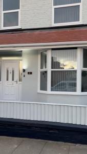 a white front door of a house with windows at Antrim Hideaway in Liverpool