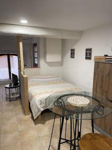 a bedroom with a bed and a glass table at ISSOIRE studio hyper centre in Issoire