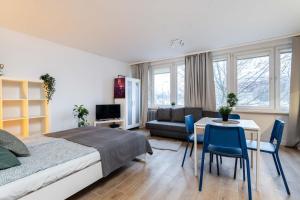 1 dormitorio con 1 cama, mesa y sillas en Passion Fruit Apartment Pge Narodowy, en Varsovia