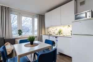cocina y comedor con mesa y sillas en Passion Fruit Apartment Pge Narodowy, en Varsovia