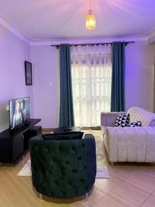 uma sala de estar com um sofá e uma mesa em Cyda Pearl Home-Buziga-Munyonyo em Kampala