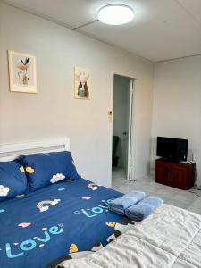 ein Schlafzimmer mit einem blauen Bett und einem TV in der Unterkunft Popular condo T8 Near Impact. in Thung Si Kan